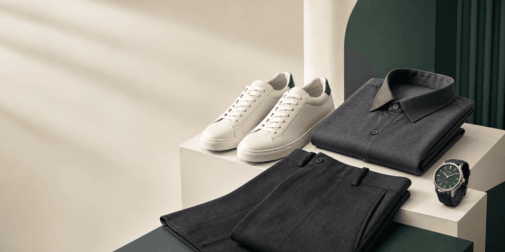 Curated shoes, folded clothing, and a wristwatch arranged for Hashmi Cart